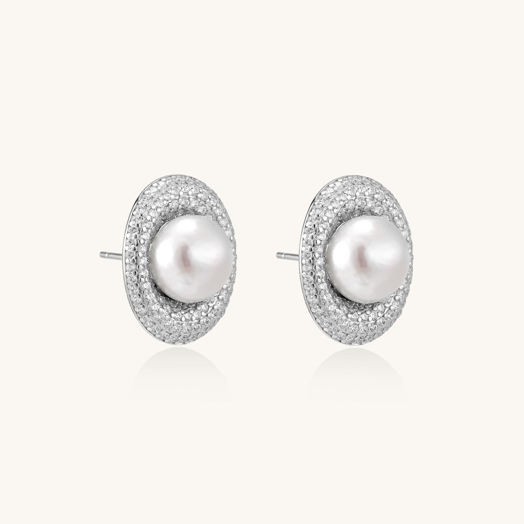 Sterling silver stud earrings with freshwater pearls surrounded by sparkling pavé crystals on white background.