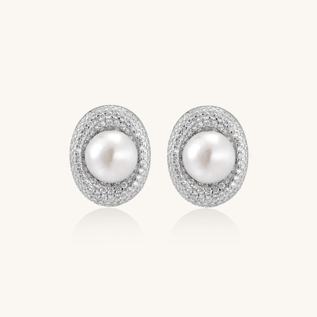 Sterling silver stud earrings with freshwater pearls surrounded by sparkling pavé crystals on white background.